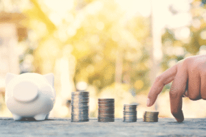 Eine Hand erklimmt eine Treppe aus Geld